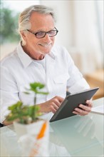 Senior man using digital tablet.