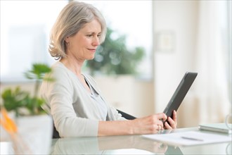 Senior woman using digital tablet.