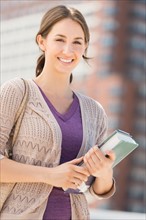 Portrait of smiling female student with book.