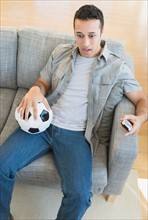 Young man watching soccer match on tv.