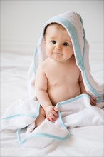 Portrait of baby girl (6-11 months) in poncho towel