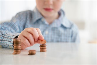 Boy (4-5) stacking coins