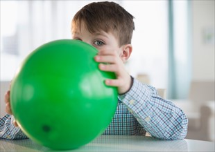 Portrait of boy (4-5) blowing balloon