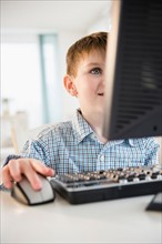 Portrait of boy (4-5) using desktop PC