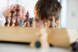 Boy (4-5) playing chess