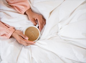 Elevated view of woman's hands holding coffee mug