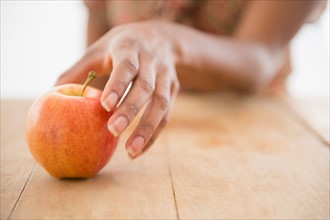 Woman's hand reaching for apple