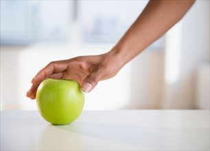 Woman's hand reaching for apple
