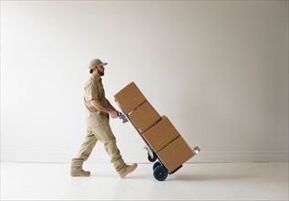 Delivery man walking with push cart