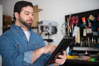 Portrait of man using digital tablet in workshop