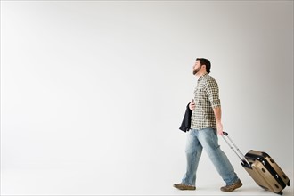 Side view of man walking with suitcase