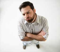Elevated view of irritated man, arms crossed