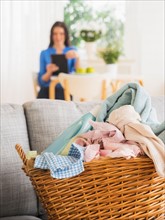 Laundry basket on sofa and woman in background
