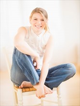 Young cheerful woman sitting on chair