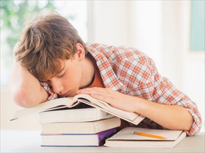 Teenage boy (14-15) sleeping in classroom
