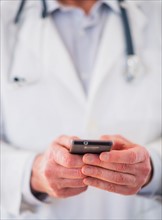 Mid section of doctor using mobile phone