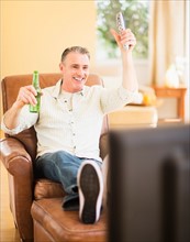 Portrait of cheerful man watching tv