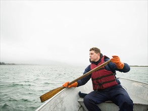 Portrait of young man paddling boat