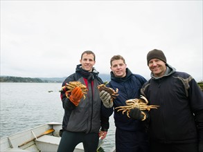 Portrait of people holding crabs