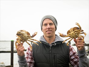 Portrait of man showing crabs