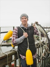 Portrait of man holding fishing equipment