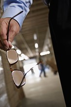 Close up of man holding eyeglasses in warehouse