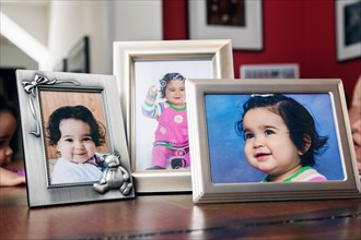 Children's (6-11 months) portraits in frames on table
