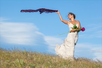 Bride standing in meadow