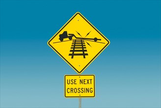 Yellow road sign depicting truck on railroad crossing