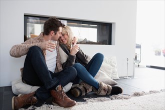Couple embracing in front of fireplace