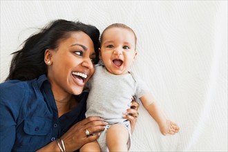 Mother with baby boy (2-5 months) hugging and laughing