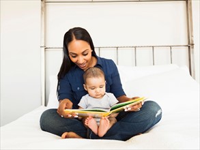 Mother showing her son (2-5 months) book and reading