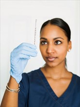 Female nurse looking at thermometer