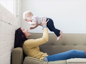 Mother holding up her daughter (12-17 months)