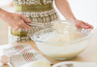 Midsection of woman whisking batter.