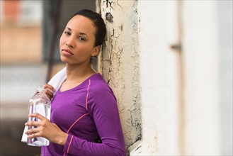 Portrait of female jogger with water bottle.