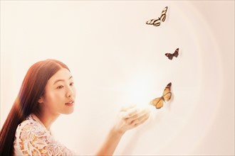 Studio shot of woman looking at butterflies.