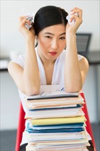 Portrait of businesswoman with stack of files.