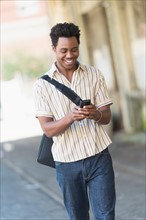 Man walking on street and text messaging.
