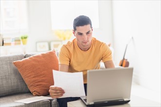 Man using laptop at home.