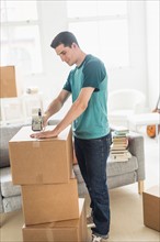 Man packing cardboard boxes at home.