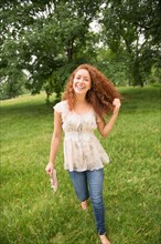 Young woman walking in park.