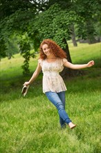 Young woman walking in park.