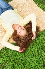 Woman lying on grass in park.
