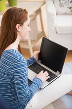 Teenage girl (14-15) studying with laptop