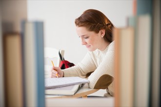 Teenage girl (14-15) studying in library