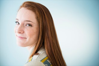 Portrait of smiling teenage girl (14-15), studio shot