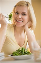 Portrait of cheerful woman eating salad