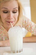 Portrait of woman blowing bubbles in milk