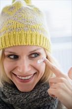 Portrait of smiling woman applying face cream
